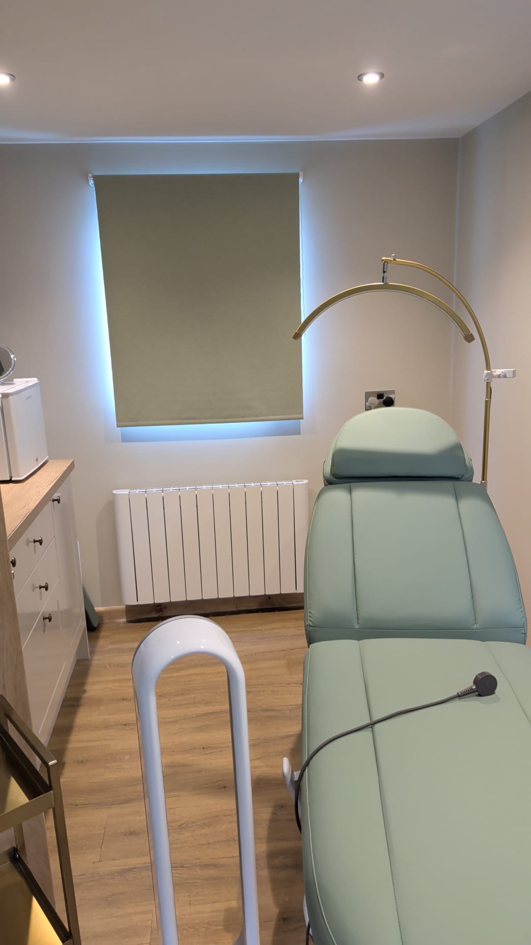 Second treatment room with sage couch and gold lamp