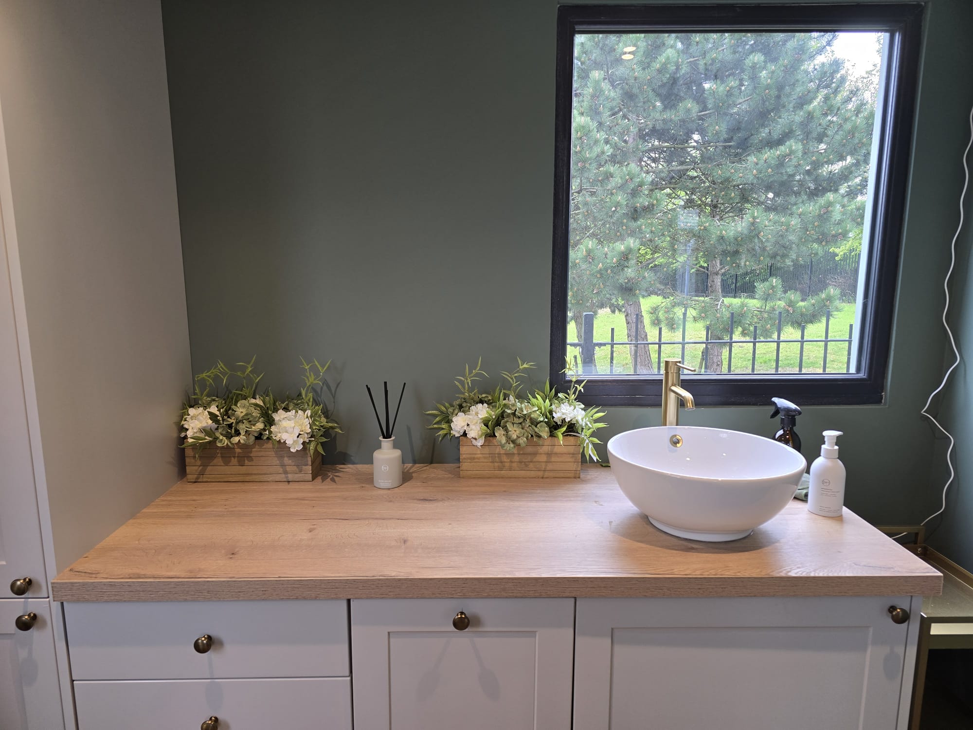 Preparation area with brass basin and greenery